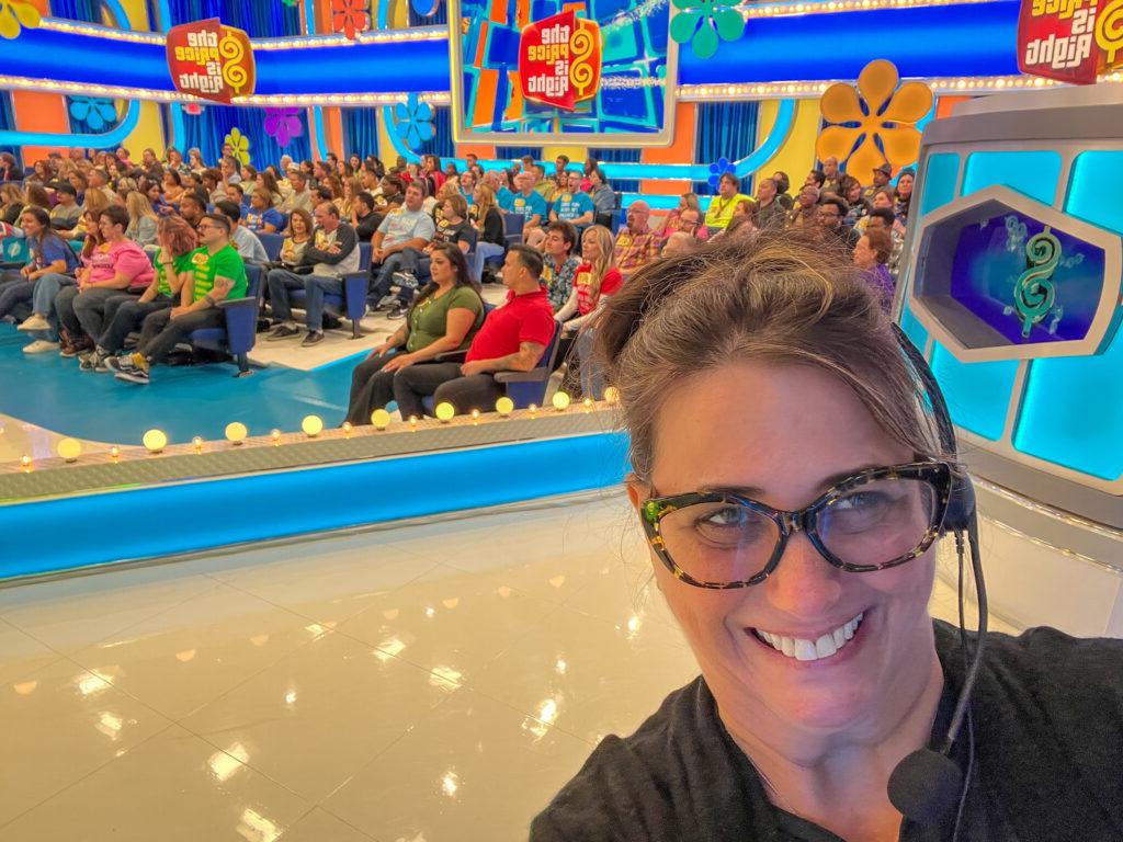Hayley Blain-Weinstein ’91 wears a headset and takes a selfie in front of the studio audience at The Price is Right.